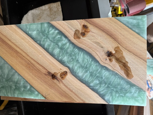 Custom charcuterie board with teal resin rivers and natural wood grain