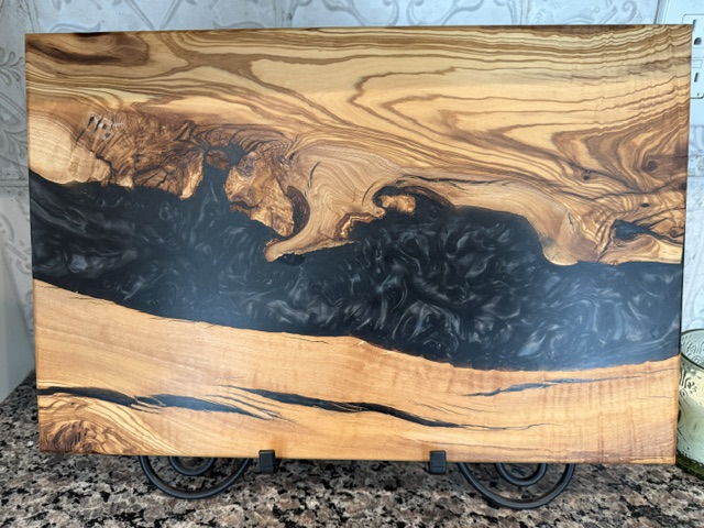 Intense olive wood grain with a dark resin swirl showing dramatic natural figure