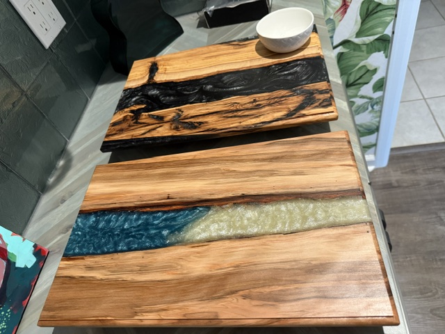 A stack of custom exotic wood boards showing the range of custom work