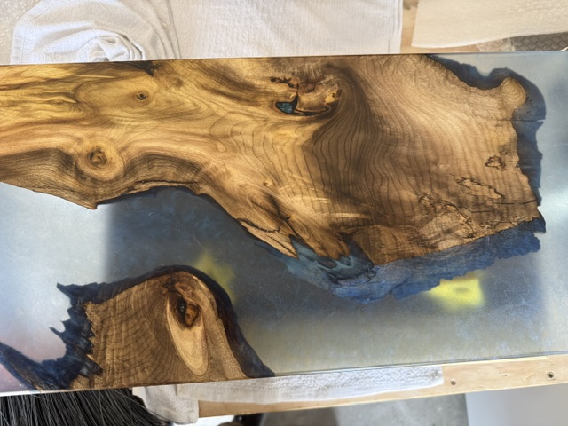 Blue resin meeting a highly figured exotic wood edge — natural color in detail